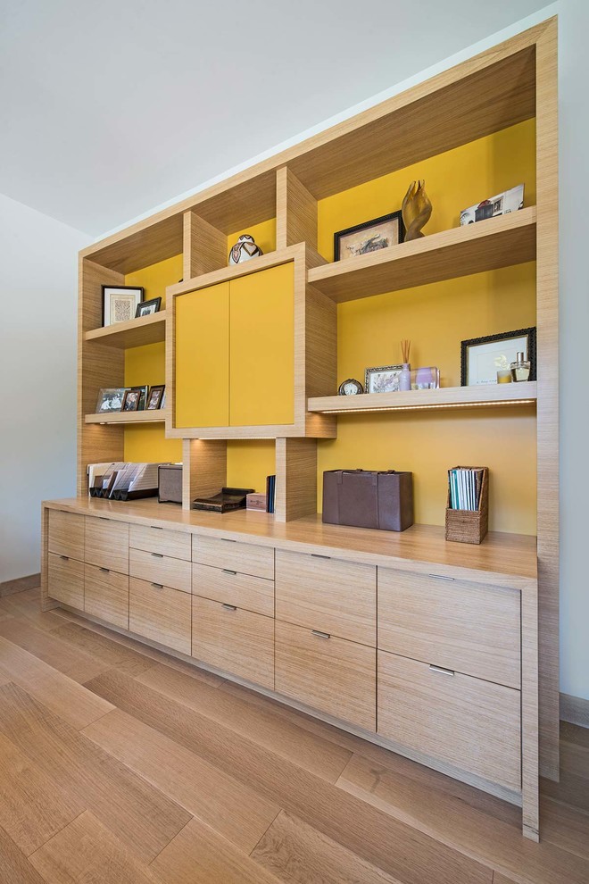 Exempel på ett modernt arbetsrum, med gula väggar