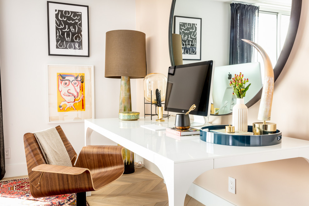 Inredning av ett modernt arbetsrum, med ljust trägolv, ett fristående skrivbord, beiget golv och vita väggar
