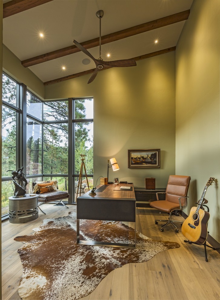 Imagen de despacho rural con paredes verdes, suelo de madera clara, escritorio independiente y suelo beige