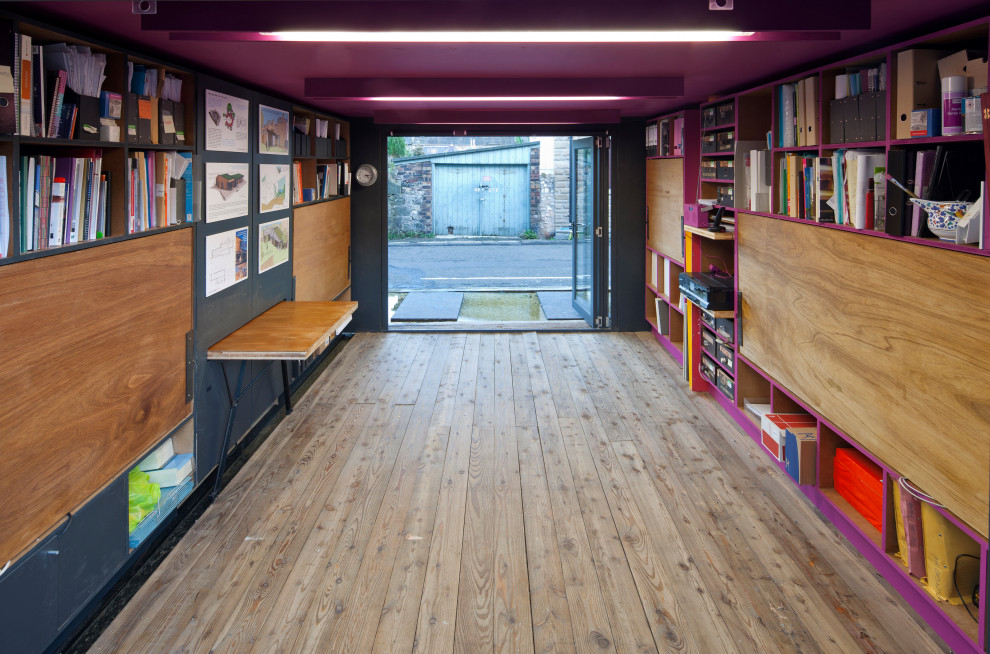 Immagine di un piccolo atelier contemporaneo con pareti viola, parquet chiaro, scrivania incassata e pavimento marrone