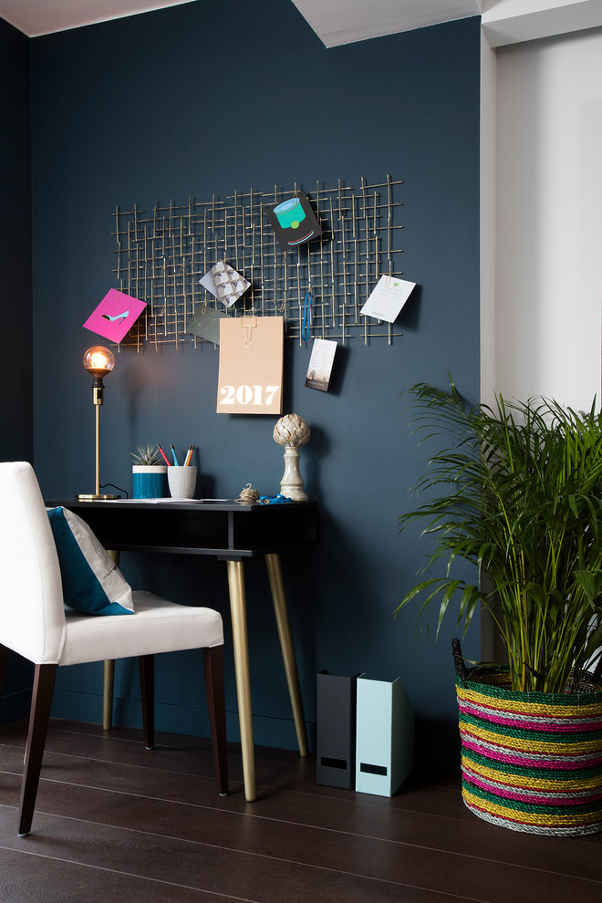 Modernes Arbeitszimmer mit beiger Wandfarbe, dunklem Holzboden, freistehendem Schreibtisch und braunem Boden in London