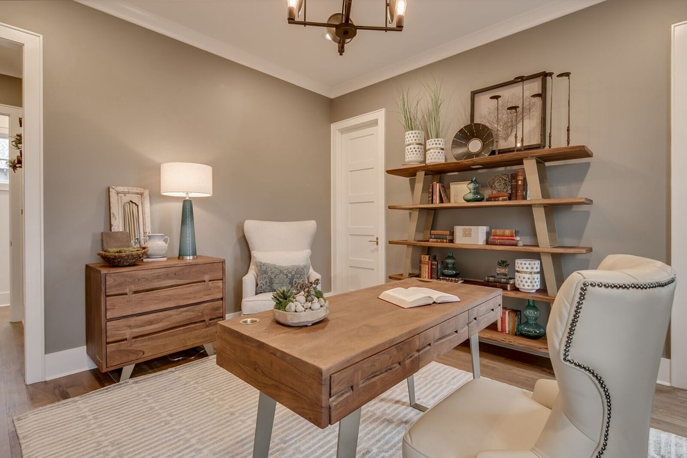 Foto de despacho de estilo de casa de campo grande sin chimenea con paredes grises, suelo de madera en tonos medios, escritorio independiente y suelo marrón