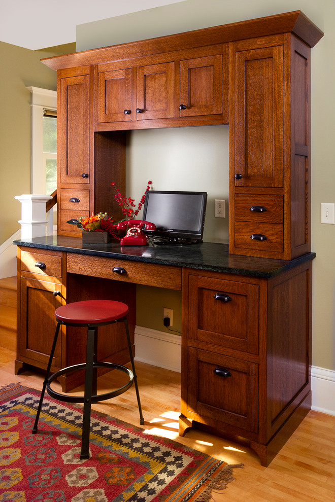 Foto de despacho de estilo americano con paredes grises, suelo de madera en tonos medios y escritorio empotrado