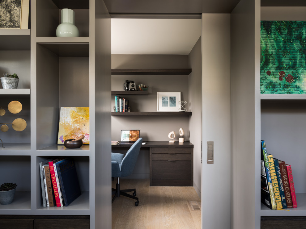 Idee per un ufficio minimal di medie dimensioni con pareti grigie, parquet chiaro, scrivania incassata e pavimento beige