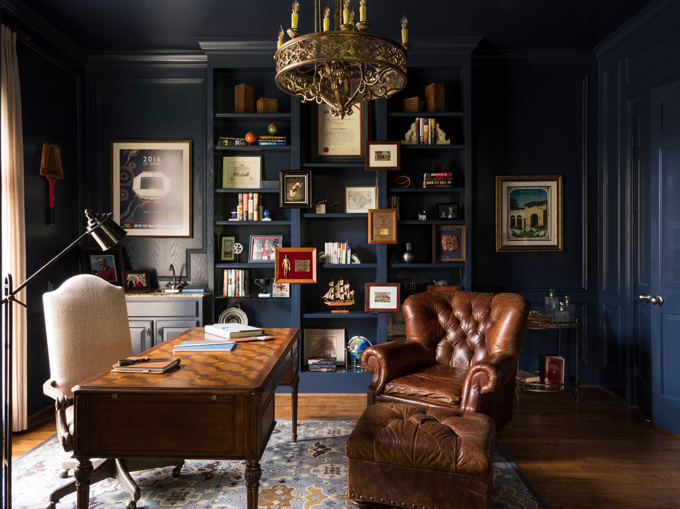 На фото: кабинет в классическом стиле с синими стенами, отдельно стоящим рабочим столом и темным паркетным полом без камина с