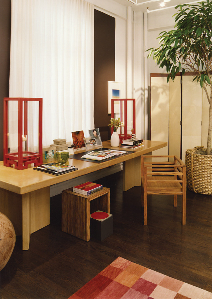 Photo of a world-inspired home office in New York with white walls, dark hardwood flooring and a freestanding desk.