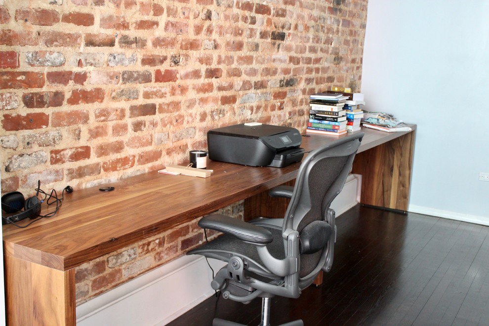 Photo of a large bohemian study in New York with dark hardwood flooring and a freestanding desk.