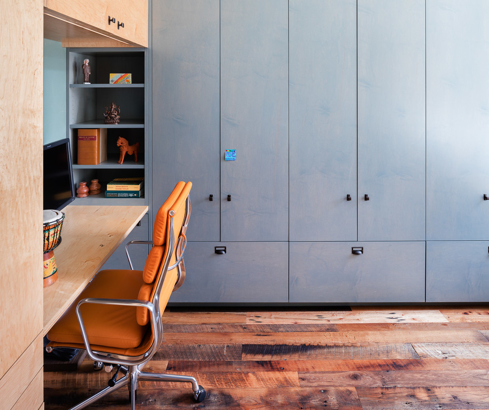 Inspiration pour un bureau de taille moyenne avec un mur bleu, parquet foncé, aucune cheminée, un bureau intégré et un sol marron.