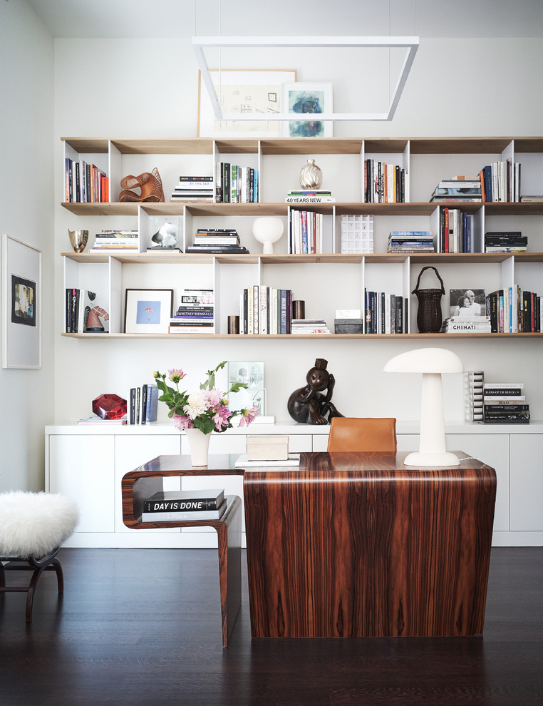 ニューヨークにあるコンテンポラリースタイルのおしゃれなホームオフィス・書斎 (白い壁、濃色無垢フローリング、自立型机、茶色い床) の写真