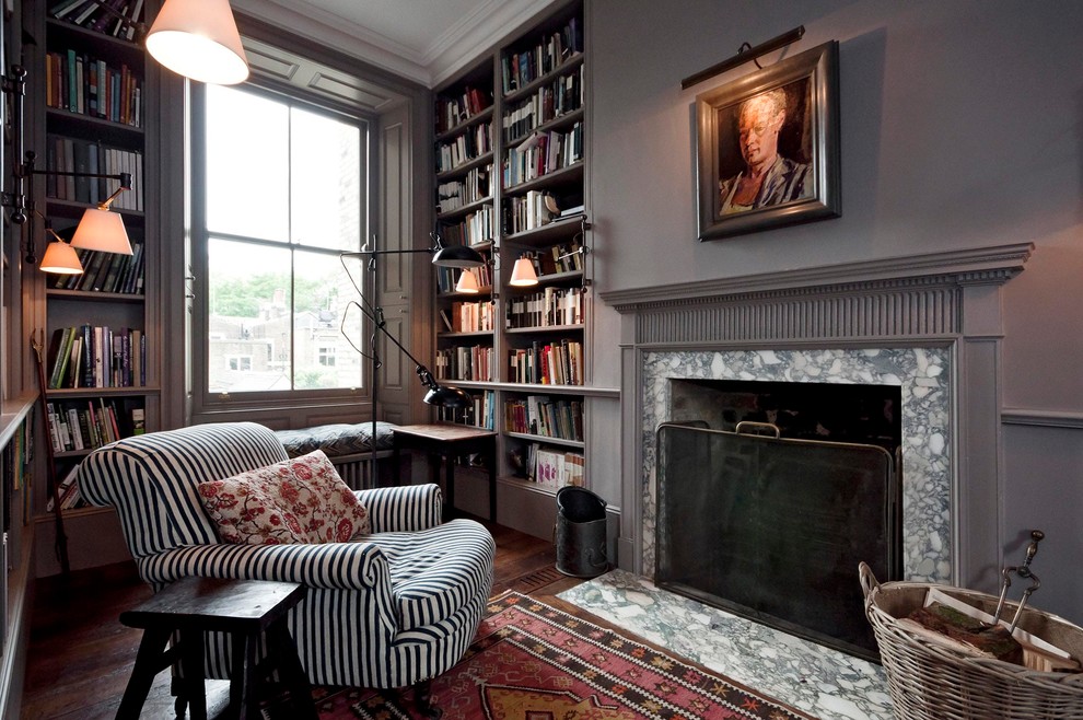 Example of an eclectic home office library design in London with a standard fireplace