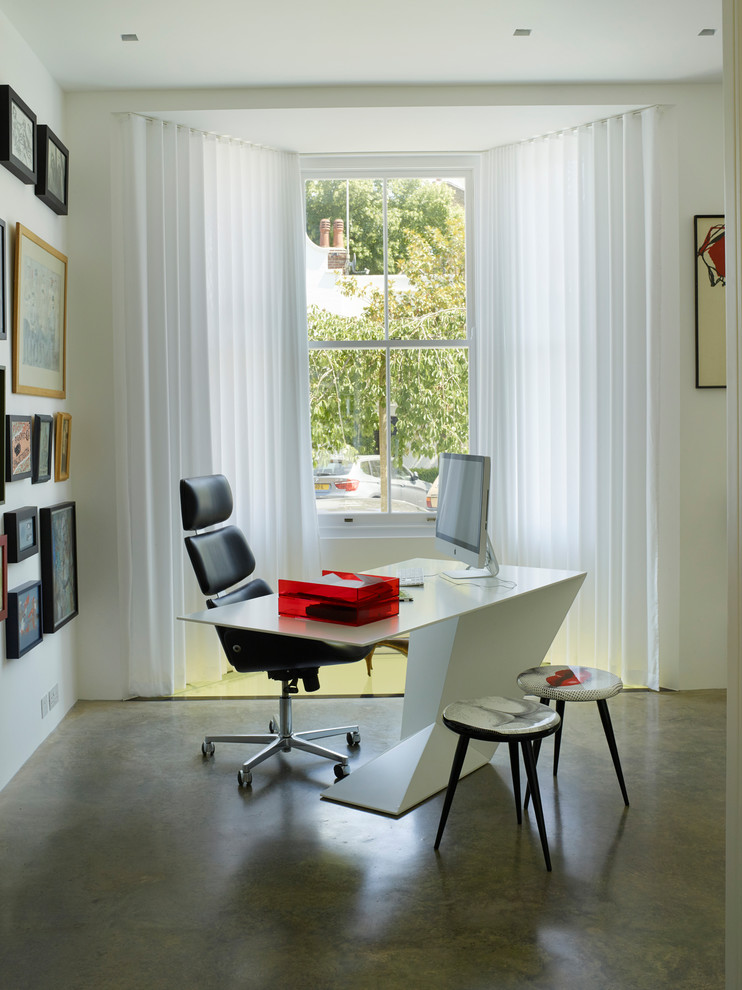 Großes Modernes Arbeitszimmer mit Studio, weißer Wandfarbe, Betonboden, freistehendem Schreibtisch und grauem Boden in London