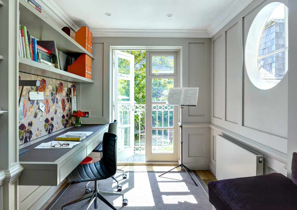 Photo of a classic study in London with grey walls, light hardwood flooring and a built-in desk.