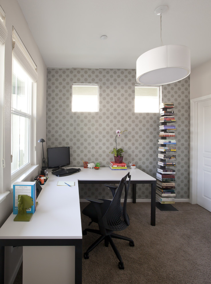 На фото: кабинет среднего размера в современном стиле с ковровым покрытием, отдельно стоящим рабочим столом, разноцветными стенами и серым полом без камина с