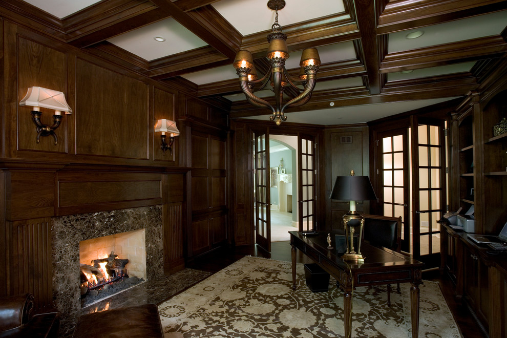 Huge elegant freestanding desk dark wood floor study room photo in Chicago with brown walls, a standard fireplace and a stone fireplace