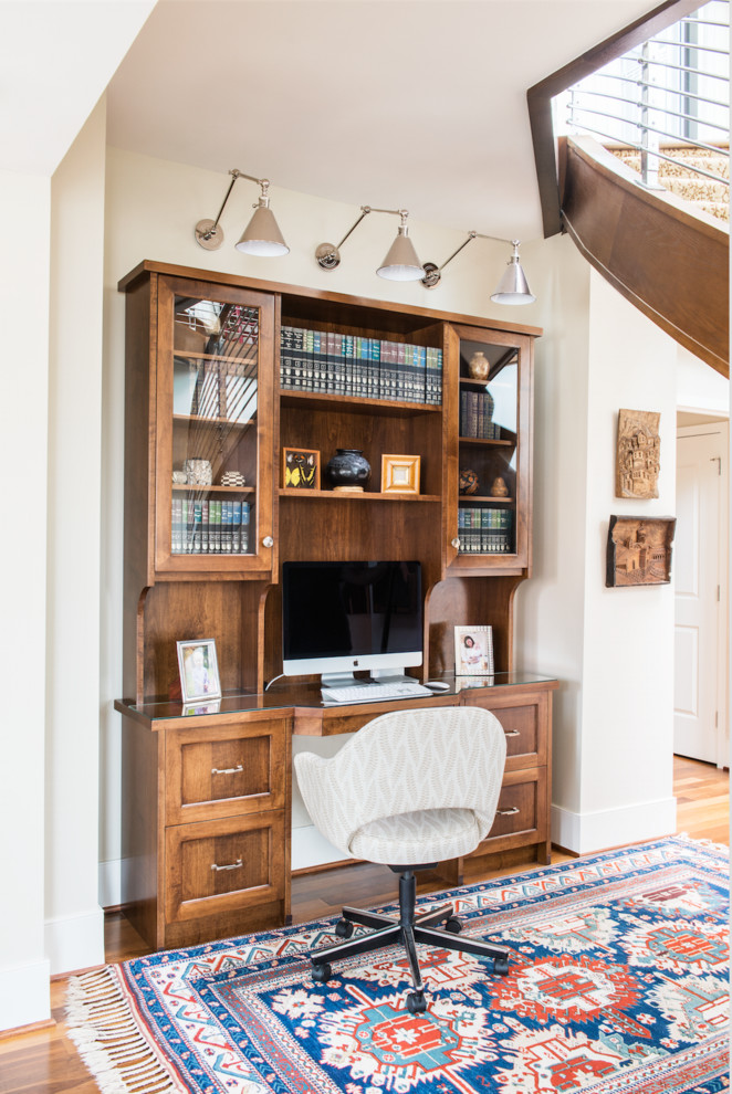 Idéer för ett klassiskt arbetsrum, med vita väggar, mellanmörkt trägolv och ett inbyggt skrivbord