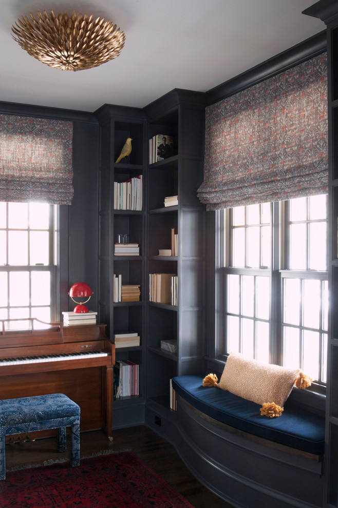 Foto på ett mellanstort funkis hemmabibliotek, med svarta väggar och mörkt trägolv