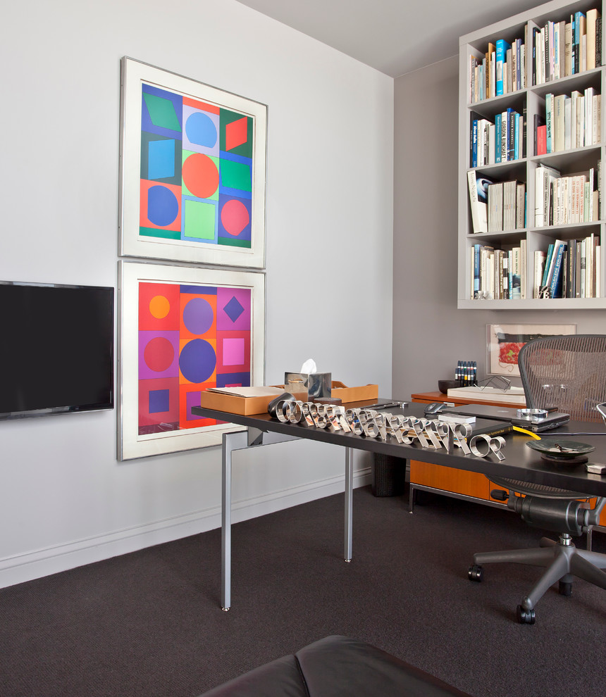 This is an example of a small contemporary study in Chicago with grey walls, carpet and a freestanding desk.