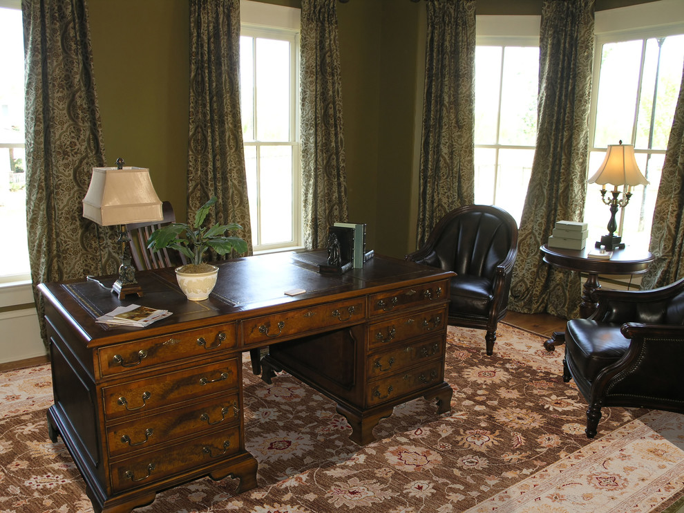 This is an example of a medium sized traditional study in Baltimore with green walls, medium hardwood flooring and a freestanding desk.