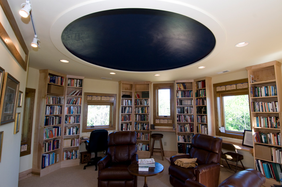 Стильный дизайн: большой домашняя библиотека с бежевыми стенами, ковровым покрытием, встроенным рабочим столом, бежевым полом, сводчатым потолком и деревянными стенами - последний тренд