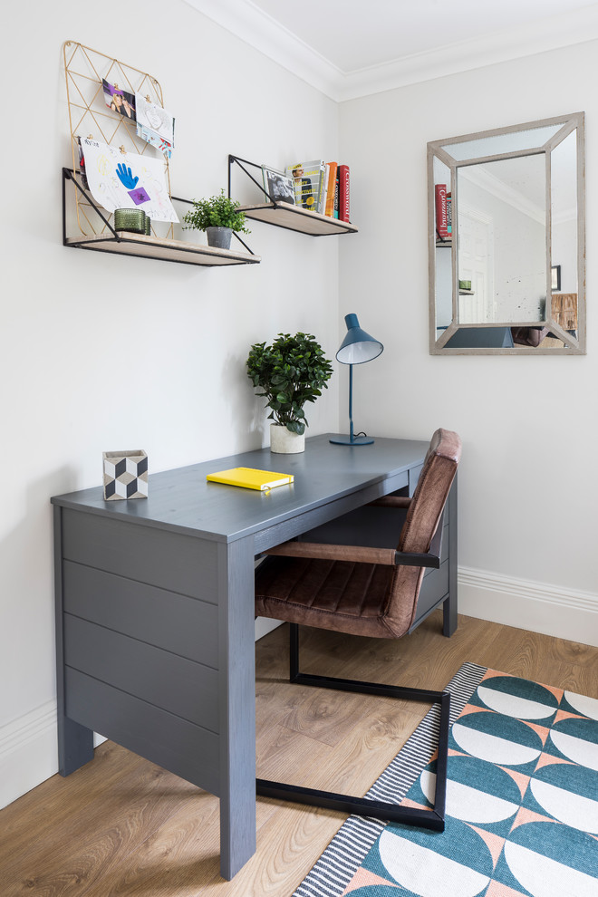 Inspiration för ett mellanstort vintage arbetsrum, med grå väggar, mellanmörkt trägolv, ett fristående skrivbord och brunt golv
