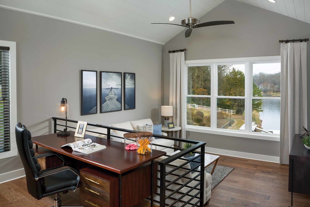 Large coastal study in Other with a freestanding desk, brown floors, grey walls, dark hardwood flooring and no fireplace.