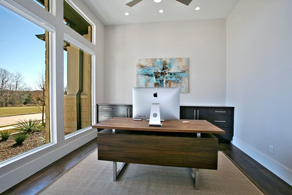 Imagen de despacho actual de tamaño medio con paredes grises, suelo de madera oscura y escritorio independiente