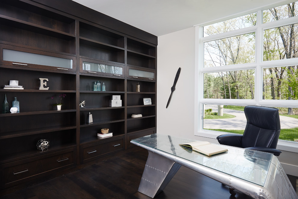 Стильный дизайн: домашняя библиотека в стиле модернизм с белыми стенами, темным паркетным полом и отдельно стоящим рабочим столом - последний тренд