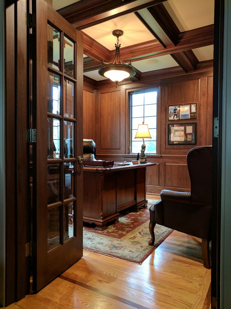 Exempel på ett mellanstort klassiskt arbetsrum, med bruna väggar, mellanmörkt trägolv, en bred öppen spis, ett fristående skrivbord och brunt golv
