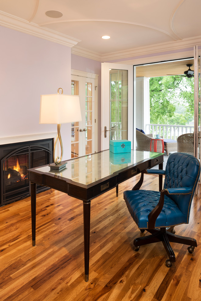 Idéer för mellanstora vintage arbetsrum, med lila väggar, mellanmörkt trägolv, en standard öppen spis och ett fristående skrivbord
