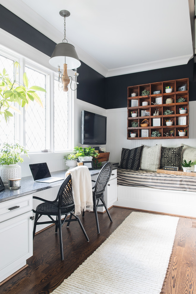 Cette photo montre un bureau chic avec un mur noir, parquet foncé, un bureau intégré et un sol marron.