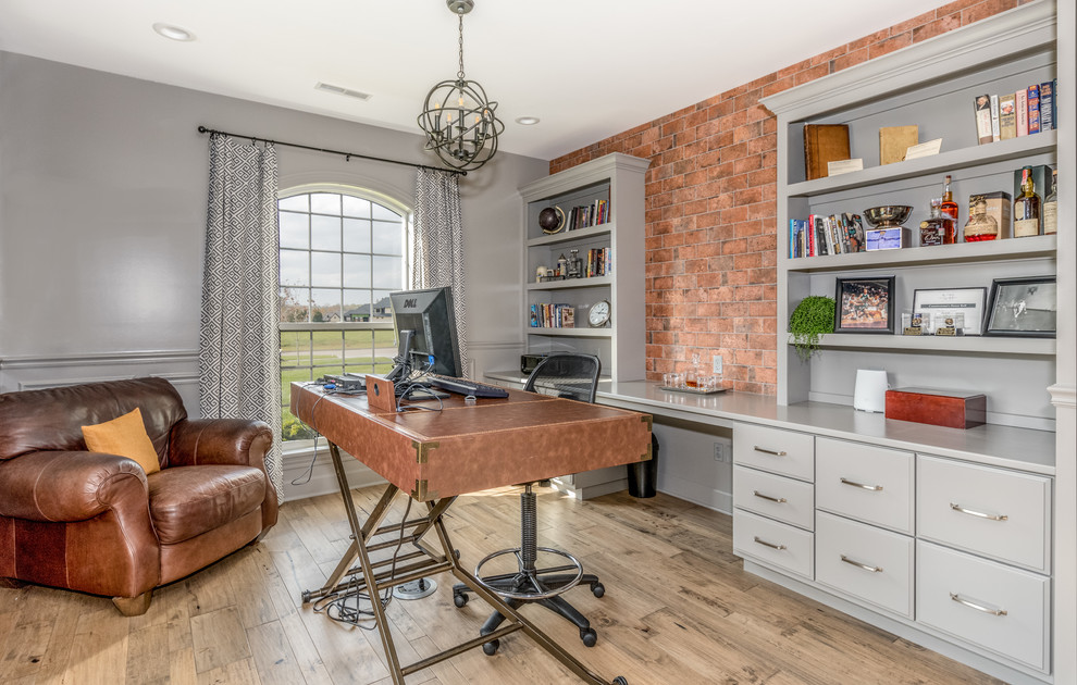 Imagen de despacho tradicional renovado con paredes grises, suelo de madera en tonos medios, escritorio independiente y suelo marrón