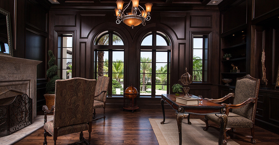 Inspiration for a mediterranean study in Miami with dark hardwood flooring, a standard fireplace, a stone fireplace surround and a freestanding desk.