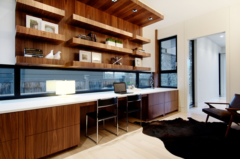 На фото: рабочее место среднего размера в стиле модернизм с белыми стенами, светлым паркетным полом и встроенным рабочим столом без камина с