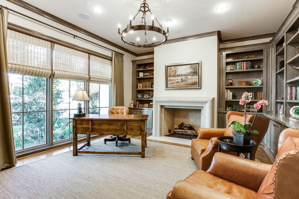 This is an example of a large traditional study in Dallas with white walls, carpet, a standard fireplace, a stone fireplace surround, a freestanding desk and grey floors.