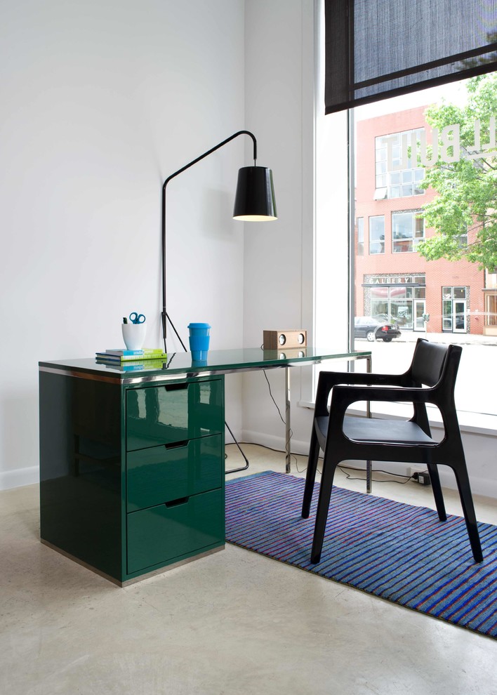Diseño de despacho moderno de tamaño medio con paredes blancas, suelo de cemento, escritorio independiente y suelo gris