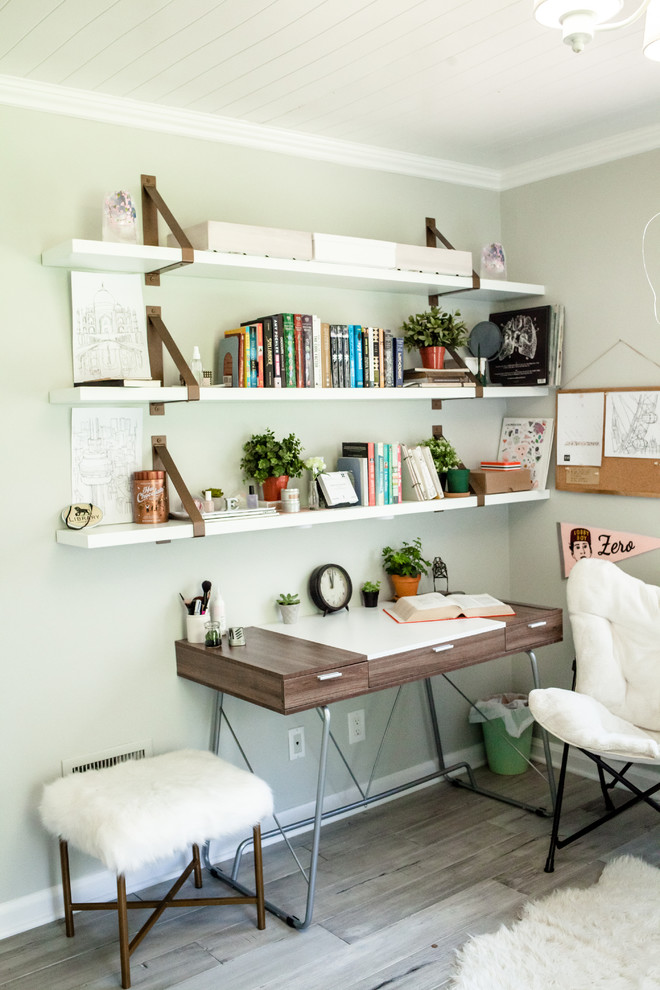 Modelo de despacho clásico renovado de tamaño medio sin chimenea con suelo de madera clara, suelo gris, paredes grises y escritorio independiente