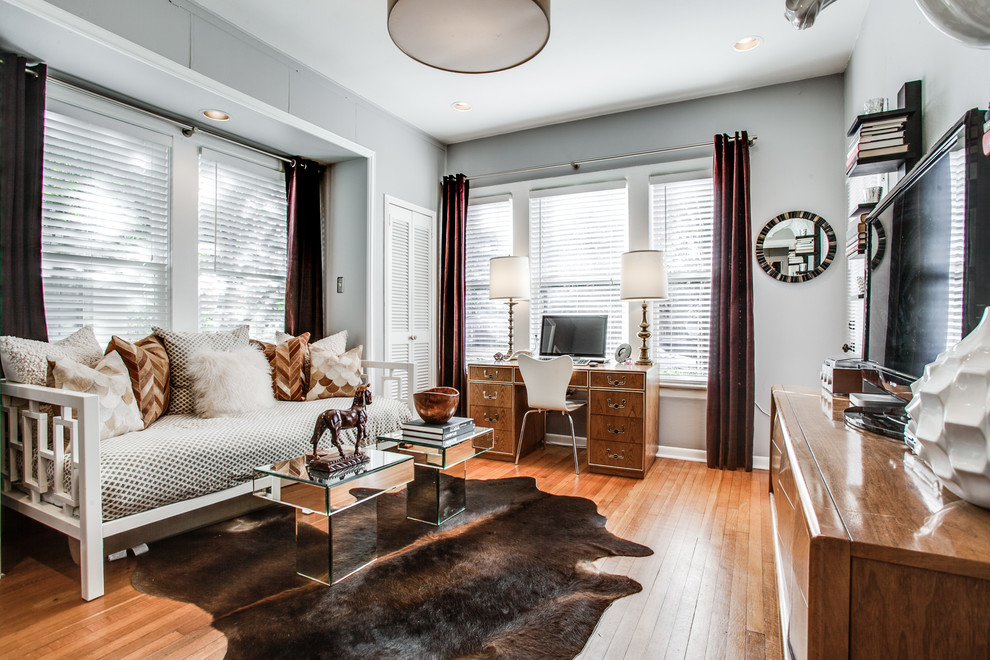 Large traditional home office in Dallas with grey walls, light hardwood flooring, no fireplace and a freestanding desk.