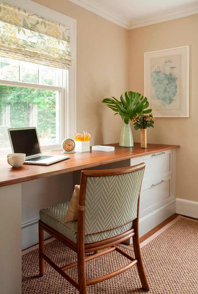 Ejemplo de despacho marinero de tamaño medio con paredes beige, suelo de madera en tonos medios y escritorio empotrado