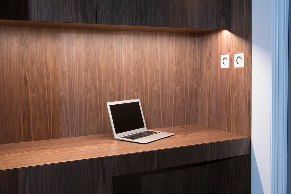 Aménagement d'un petit bureau contemporain avec un bureau intégré, un mur gris, un sol en bois brun, aucune cheminée et un sol marron.