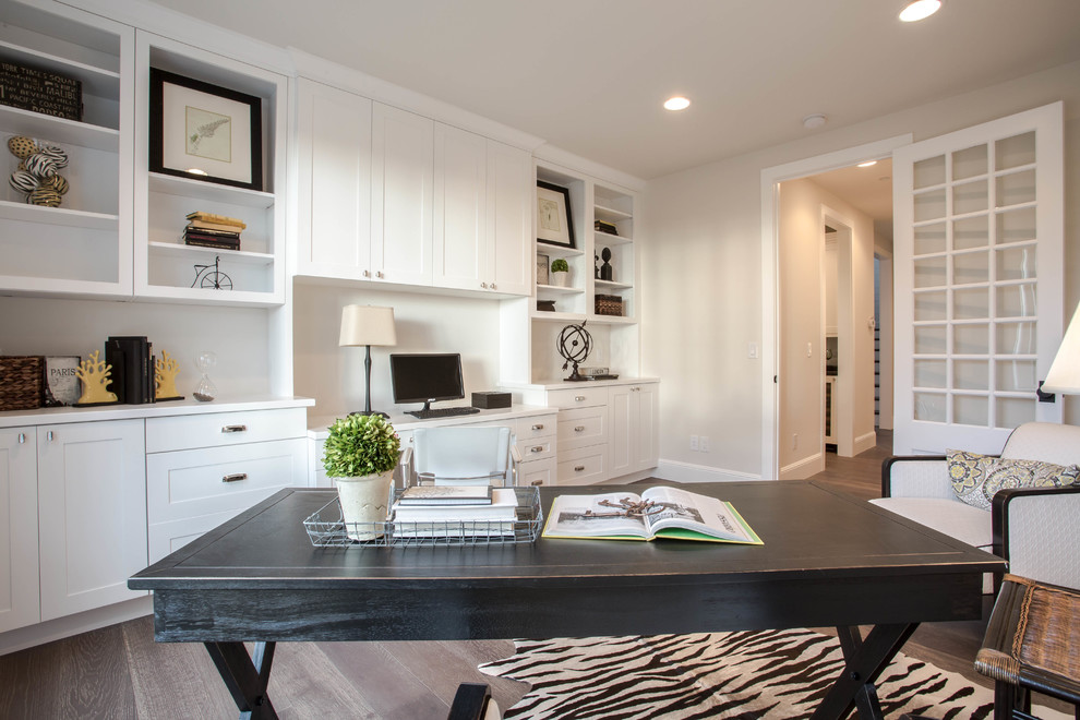 Ejemplo de despacho de estilo de casa de campo extra grande sin chimenea con paredes blancas, suelo de madera oscura y escritorio independiente