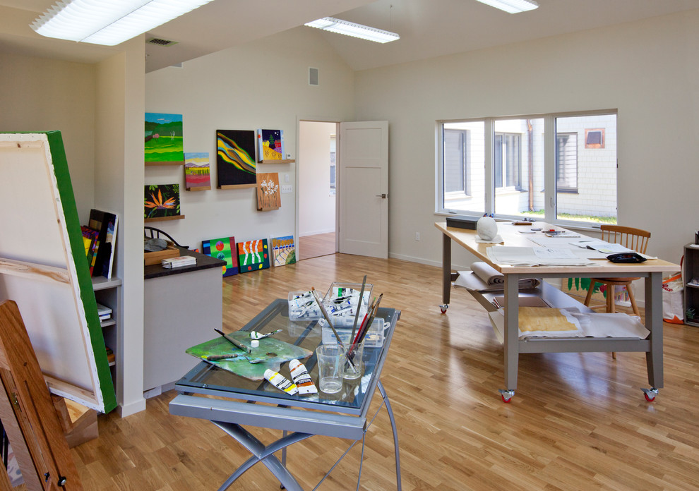 Foto på ett funkis hemmastudio, med mellanmörkt trägolv och ett fristående skrivbord