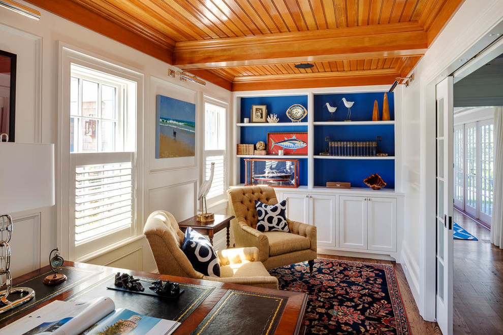 Imagen de despacho marinero pequeño sin chimenea con paredes blancas, suelo de madera en tonos medios y escritorio independiente