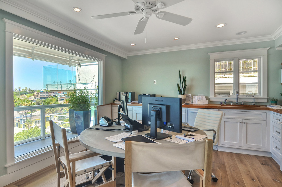 Mittelgroßes Maritimes Arbeitszimmer ohne Kamin mit blauer Wandfarbe, hellem Holzboden und Einbau-Schreibtisch in Orange County