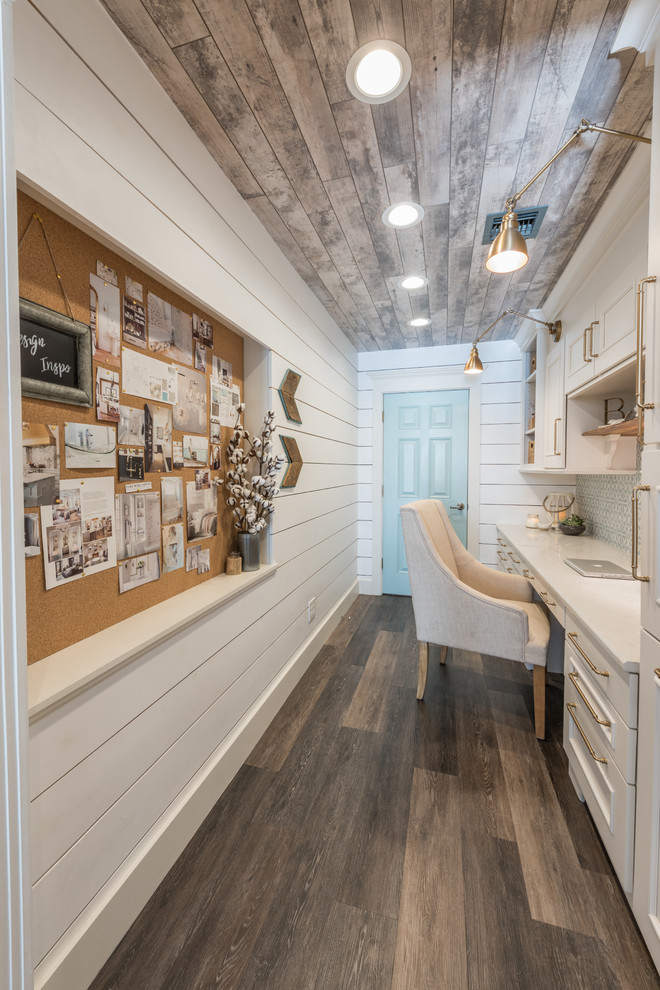 Diseño de despacho campestre pequeño con paredes blancas, suelo vinílico, escritorio empotrado y suelo marrón