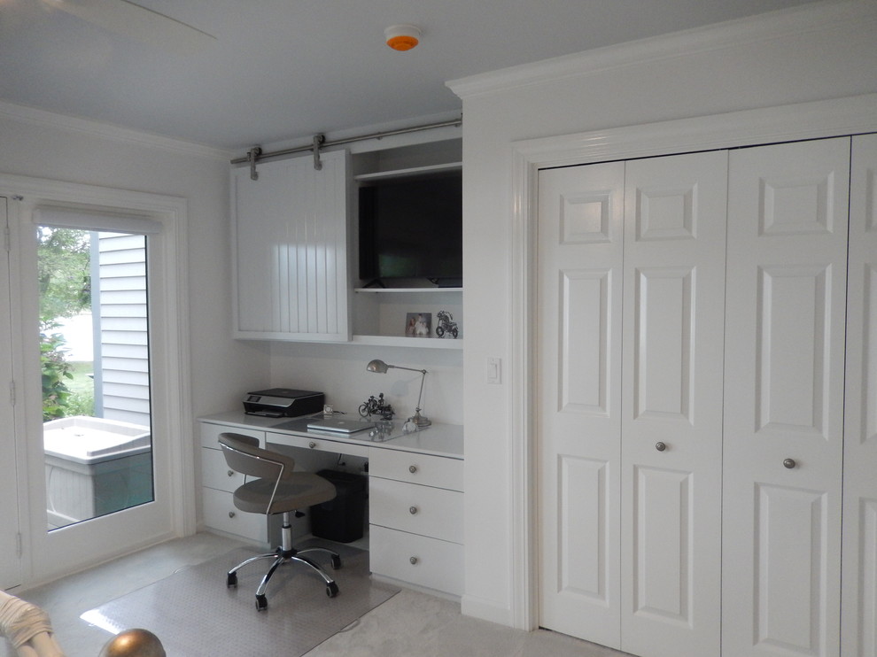 На фото: маленький кабинет в морском стиле с белыми стенами, встроенным рабочим столом и серым полом для на участке и в саду