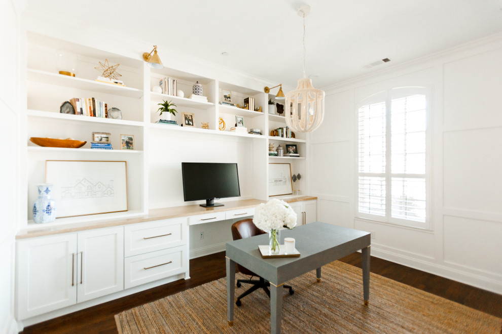 Foto de despacho tradicional renovado grande con paredes blancas, suelo de madera oscura, escritorio independiente y suelo marrón
