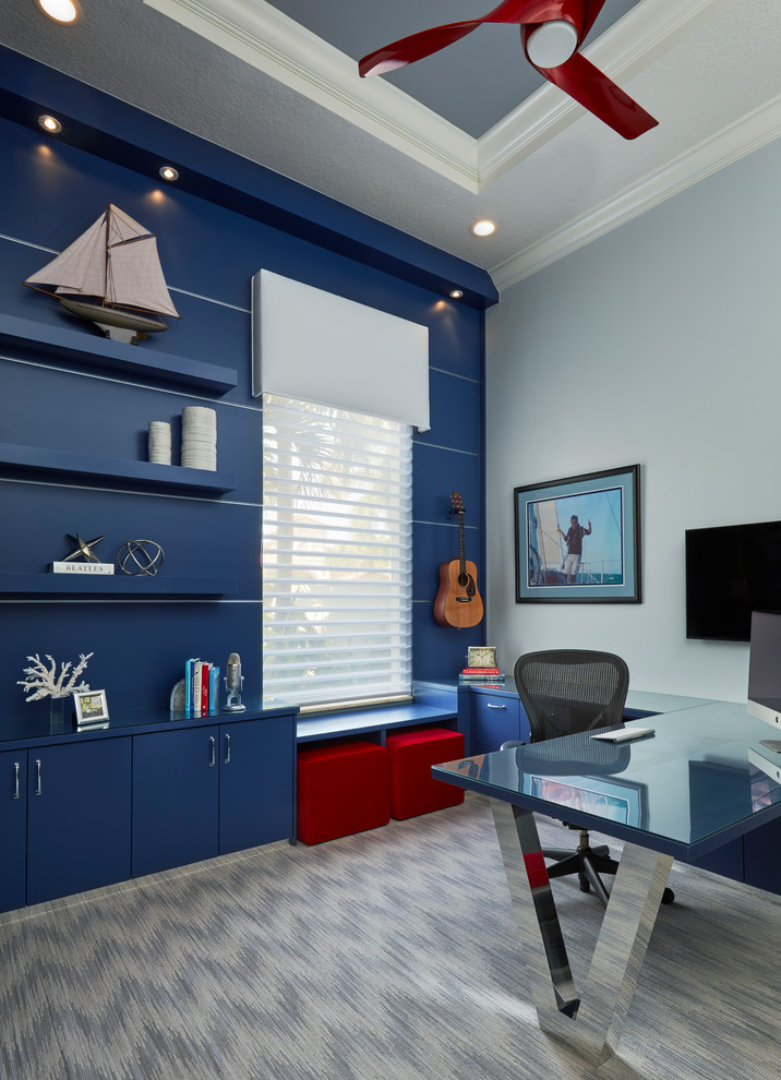 Inredning av ett modernt mellanstort arbetsrum, med blå väggar, heltäckningsmatta och ett inbyggt skrivbord