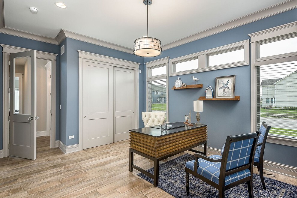 Imagen de despacho clásico renovado de tamaño medio con paredes azules, suelo de madera en tonos medios, escritorio independiente y suelo beige