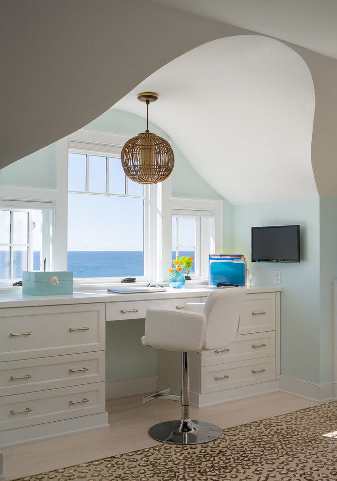 Foto de despacho costero con paredes verdes, suelo de madera clara y escritorio empotrado