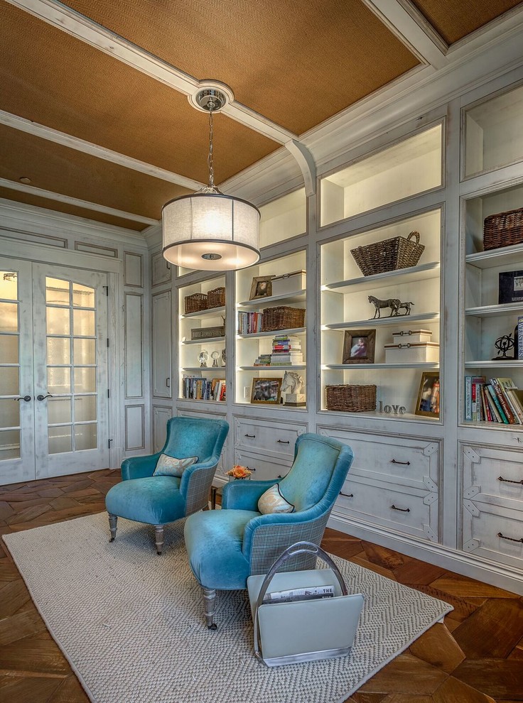 Imagen de despacho tradicional de tamaño medio con biblioteca, paredes blancas, suelo de madera oscura y suelo marrón